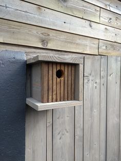 a bird house built into the side of a wooden building