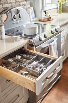 an open drawer in the middle of a kitchen