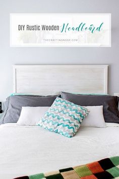 a bed with a white headboard and two pillows on it, next to a sign that says diy rustic wood