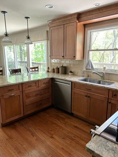 a kitchen with wooden cabinets and stainless steel appliances, along with an island in the middle