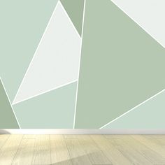 an empty room with wood flooring and a wall painted in pastel green tones