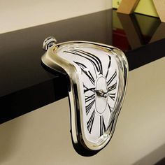 a clock that is on the side of a wall with black and white designs around it