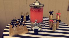 a table topped with bottles and drinks on top of a black and white striped table cloth