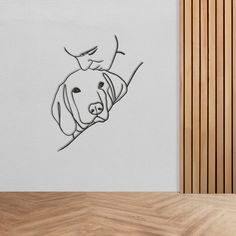 a drawing of a dog's head on the wall next to a wooden floor