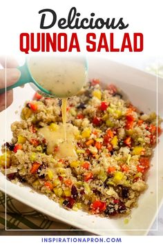 quinoa salad with dressing being drizzled over it in a white dish