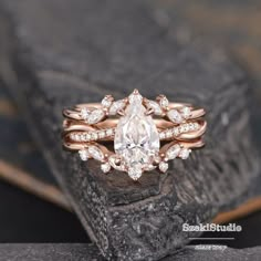 an engagement ring with a pear shaped diamond surrounded by smaller round diamonds on top of it