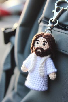 a crocheted jesus keychain hanging from a backpack