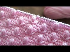 a close up view of a pink crocheted blanket