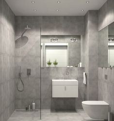 a bathroom with a toilet, sink and shower stall in grey tiles on the walls