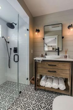 a bathroom with a sink, mirror and shower stall in the middle of the room