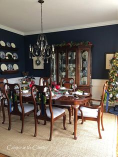 the dining room is decorated for christmas with blue walls and white trim around the table