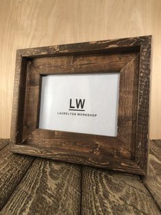 a wooden frame sitting on top of a table with the word lw written in it