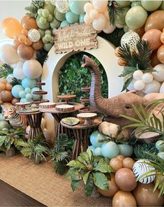 an elephant and giraffe themed birthday party with balloon garlands, jungle theme