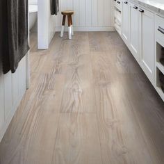 a kitchen with white cabinets and wood flooring