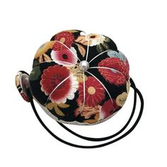 a black and red flowered ball on a string with two white balls in the middle