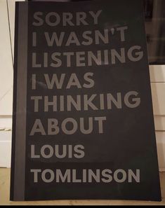 a sign that is on the side of a building reading sorry i was listening i was thinking about louis tomkinson