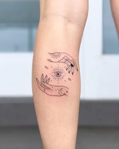 a tattoo on the leg of a woman with two birds flying over her head and an eye in the sky