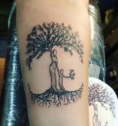 a couple hugging under a tree tattoo on the arm