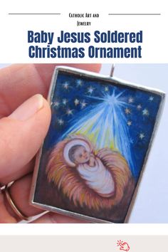 baby jesus soldered christmas ornament being held by a person's hand