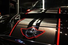 the front end of a black car with red and white stripes