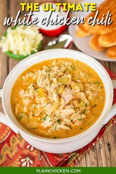 the ultimate white chicken chili in a bowl with bread and other food on the side