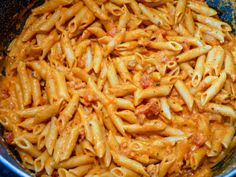 a pan filled with pasta and sauce on top of a stove