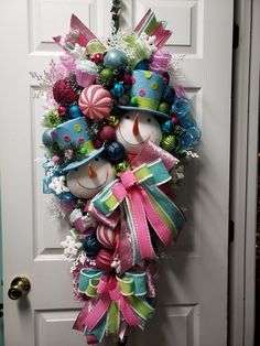 a christmas wreath on the front door decorated with candy canes and candies,