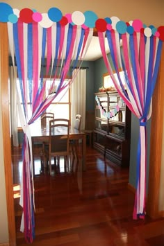 a room decorated with pink, blue and white striped drapes on top of wooden floors