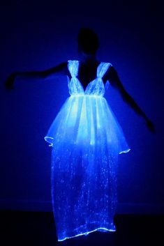 a woman in a dress that is glowing blue