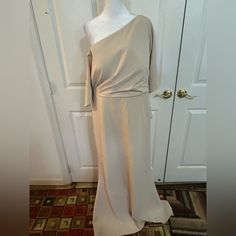 a mannequin wearing a white dress in front of a door