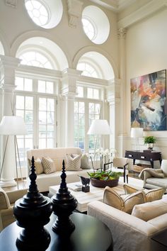 a living room filled with furniture and large windows