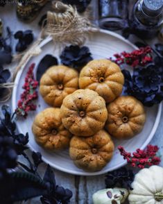 small pumpkins on a white plate surrounded by halloween decorations