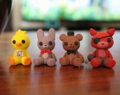 four small toy animals sitting on top of a wooden table