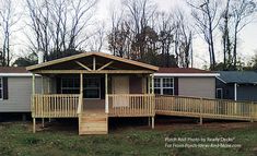 a mobile home sits in the middle of a grassy area with two porches on each side