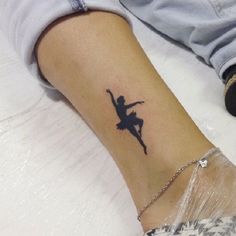 a person with a tattoo on their arm is sitting down and holding her leg in the air