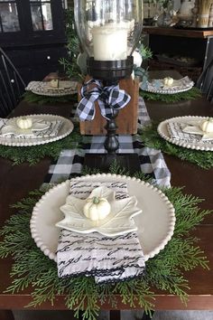 the table is set with plates, napkins and candles on top of each plate