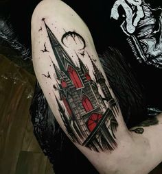 a man with a tattoo on his arm has a red and black castle in it