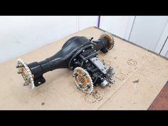 an image of a motor that is on the ground with chains attached to it's gears