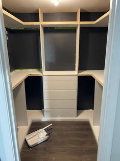 an empty walk - in closet with black and white shelvings on the floor