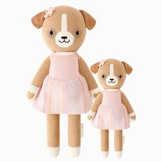 a brown teddy bear wearing a pink dress and standing next to a tan teddy bear