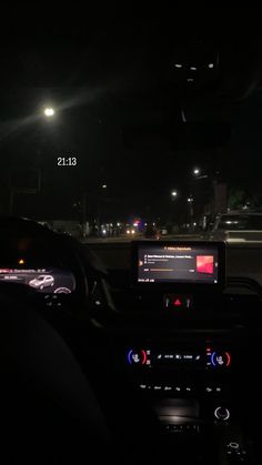 the interior of a car at night with its lights on and dashboard illuminated by streetlights