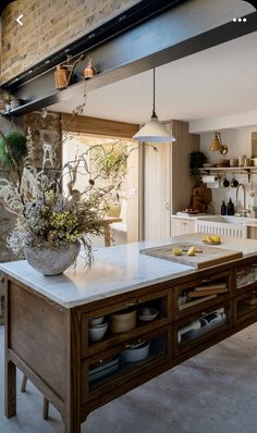 a kitchen with an island in the middle and lots of pots on top of it