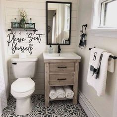 a white toilet sitting next to a sink in a bathroom under a mirror with words above it