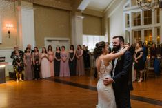 a bride and groom share their first dance at the wedding reception in front of an audience