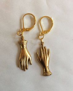 A pair of mixed matched elegant hands two hand earrings created from two Victorian styled findings raw brass gold tone charms For pierced ears with leverback fittings Perhaps a present for an engagement or wedding with the emphasis on hands in both celebrations.  Please note that the hands are identical and therefore not a true 'pair' of hands.  These earrings hang one from the fingers, and the others hang from the cuff, so it is like giving someone a hug I also have earrings that both hang from the fingers, or a pair that both hang from the cuffs Raw brass has all the colour of 9ct gold without the price tag The charms are single sided stamped metal and are therefore hollow backed and lovely and light to wear Please note these are vintage findings so I haven't polished them as some purcha Gold Hand Cast Metal Jewelry, Hand Cast Gold Plated Jewelry, Victorian Brass Jewelry With Lobster Clasp, Victorian Jewelry With Lobster Clasp In Brass, Gold 14k Lever Back Jewelry, Hand-cast Brass Jewelry For Anniversary, Gold Lever Back Earrings For Gift, Elegant Hand Cast Gold Earrings, Formal Brass Jewelry With Lobster Clasp