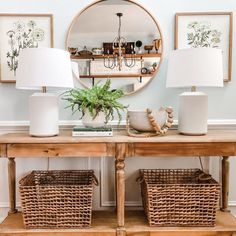 two wicker baskets sit on top of a wooden table in front of a mirror