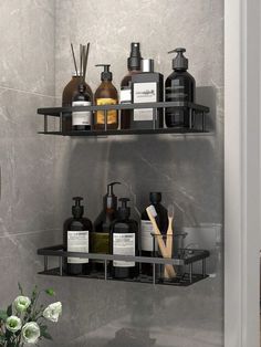 two black shelves with soap, lotion and other items on them in a bathroom