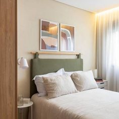 a bed with white sheets and pillows in a bedroom next to a wooden closet door