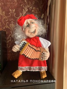 an old woman doll is playing the accordion