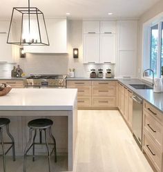 a large kitchen with two stools at the island